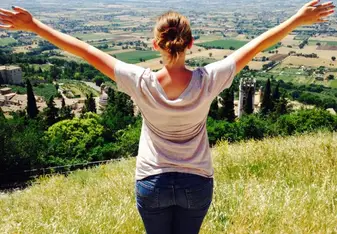 A woman stretching her hands towards the horizon.