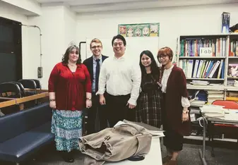 Group of people posing for a photo inside an office.