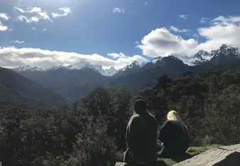 Two persons sitting by the cliff.
