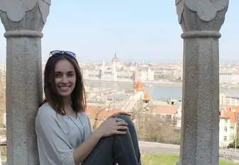 A woman sits showing the view of the Parliament.