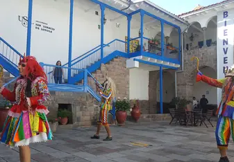 Three persons in costumes perform a dance.