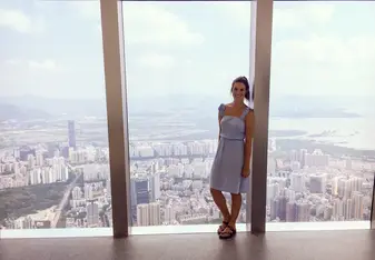 a woman standing on a huge window 