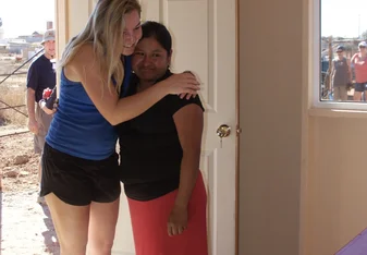 a young lady hugging a sad and crying woman