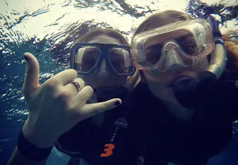 photo of 2 woman under the sea while snorkling