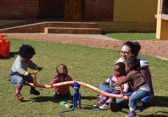 a woman playing with children on the playground
