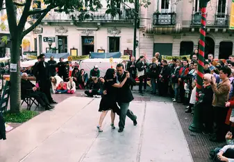 a man and a woman dancing tango in the middle of the street