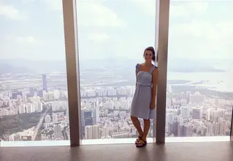 a woman standing on a huge window 