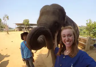 A girl and a kid with an elephant.