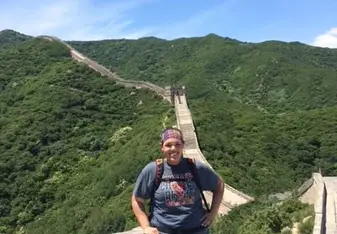 A woman poses at the Great Wall of China.