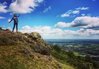 A woman poses on top of a mountain.