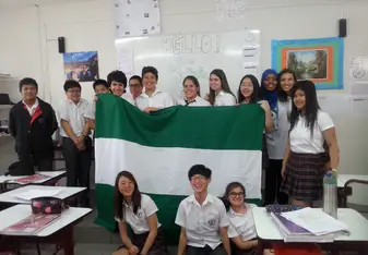 students inside the classroom holding a huge green and white flag
