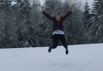 a woman jumping high on snow