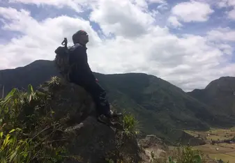man sitting on top of the mountain