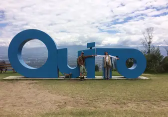 man and woman having their picture on Quito signage