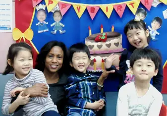 a woman happily posing for photo with the little children
