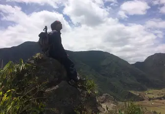 man sitting on top of the mountain