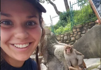 a young girl with a monkey beside her