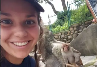 a young girl with a monkey beside her