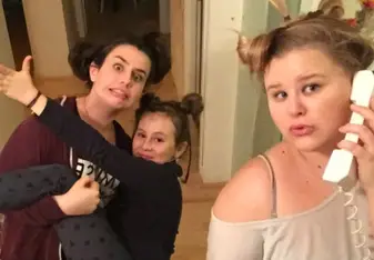 two young woman goofing around with a cute little girl