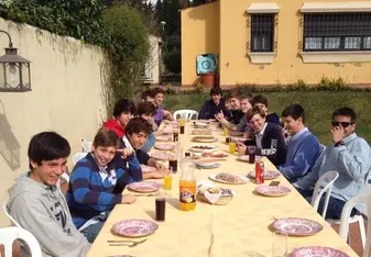Group of people sharing food at a long table.