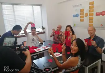 People showing cut-out Chinsese characters.