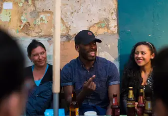 Three persons talking over some drinks.