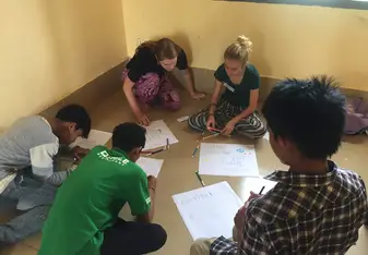 A group of people drawing on paper.