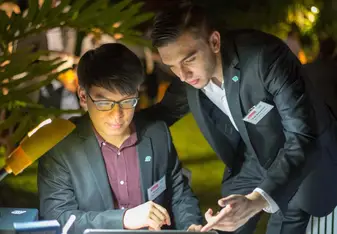 Two guys looking at a laptop.