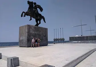 A group poses for a photo at a huge statue.