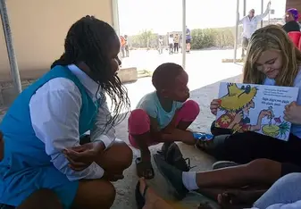 A woman reads a story to children.