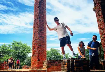 A man stands at a structure in a tourist spot.