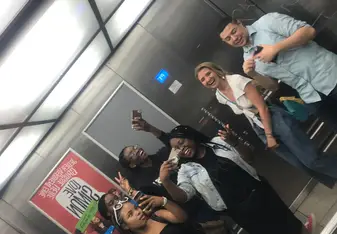A group of people snaps photos inside an elevator.