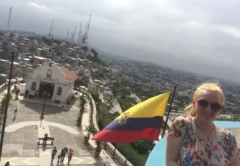 Standing in front of the Ecuadorian flag with a view of the city of Guayaquil, Ecuador
