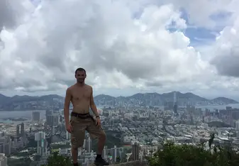 A guy stands at a spot overlooking the cityscape.