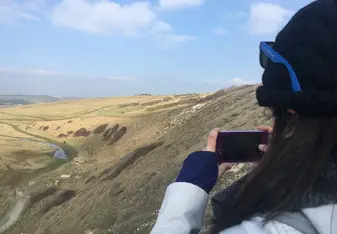 A woman takes a photo of the landscape.