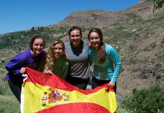 Four women holding the flag of Spain.