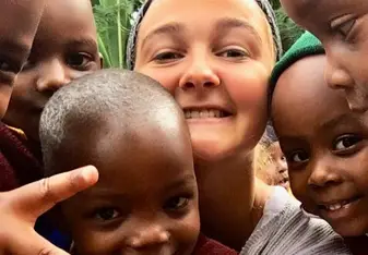 A woman and some children smile for a photo.