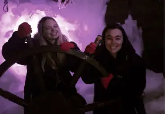Two women inside an ice bar.