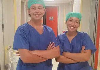 Two persons in scrub suit posing for a photo.