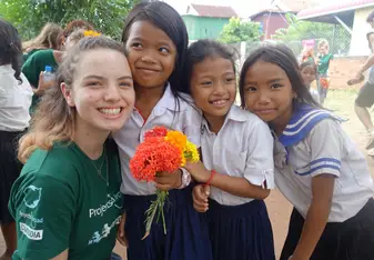 A volunteer takes a photo with girl students.