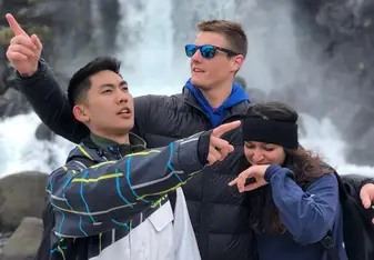 Three people posing for a photo at a waterfalls spot.