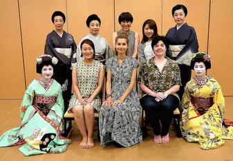 Group photo with women made up women dressed in traditional Japanese costume.