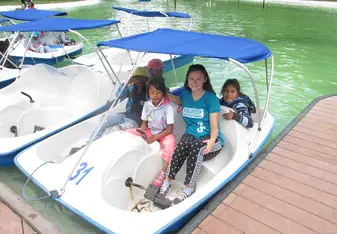 A woman in a boat with four children.