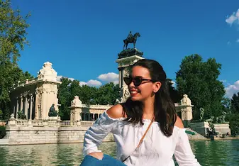 A woman poses at a tourist spot while riding a boat.