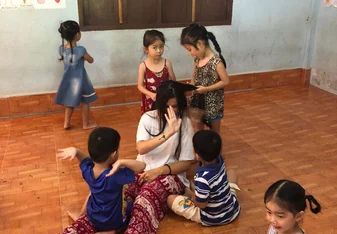 A woman interacts and plays with children.