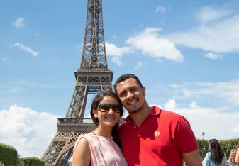 A couple poses near the Eiffel Tower.