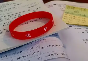 A wrist band with Chinese writing.