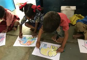 Students in Udaipur coloring pictures in class with STEP Volunteers
