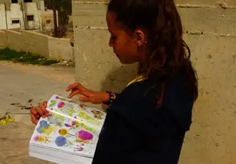 A young girl holds a book.