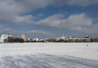 A river is covered by snow and complements the blue sky and white clouds.